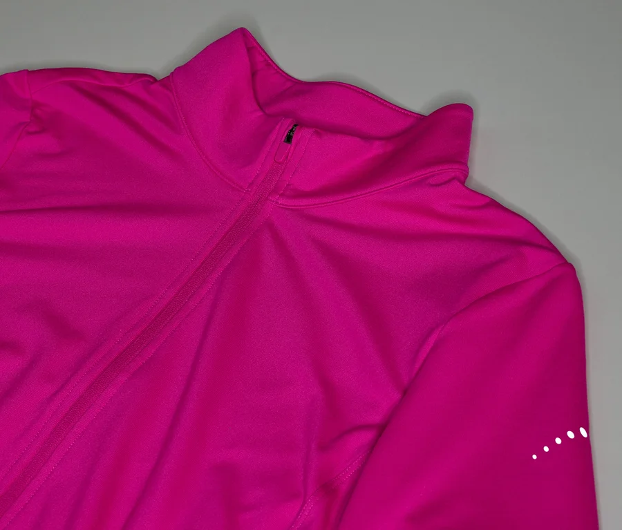 Gros plan d'une veste de survêtement rose avec fermeture éclair et col montant.