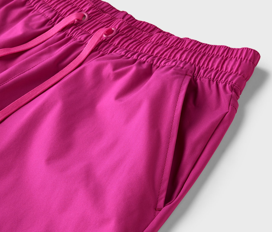 Gros plan d'un pantalon rose avec un cordon de serrage et une poche sur le côté droit.