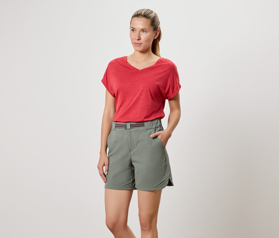 Femme portant un t-shirt rouge et un short vert.