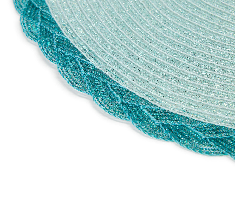 Gros plan d'un napperon rond scintillant turquoise et blanc avec une bordure tressée.