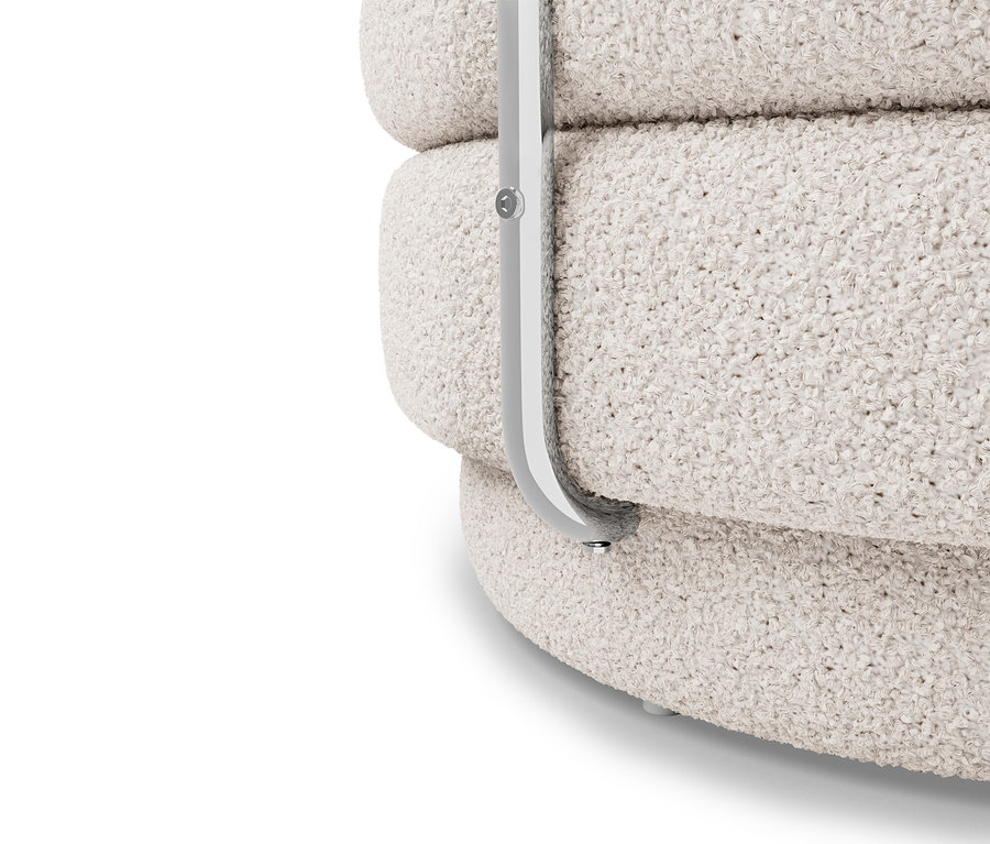 Gros plan d'un fauteuil bouclé crème avec un cadre en métal argenté.