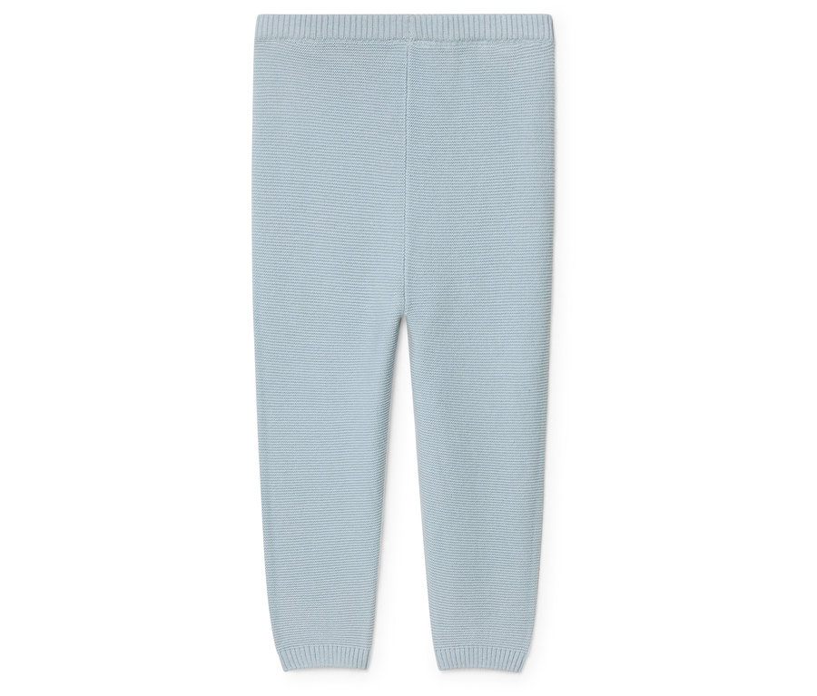Un pantalon de bébé bleu clair en tricot sur un fond blanc.