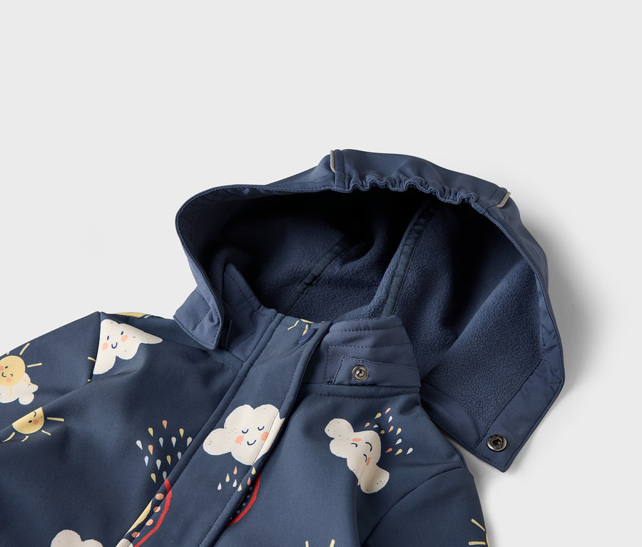 Vue détaillée d'une veste bleu marine à capuche, ornée de motifs de nuages et de soleil.