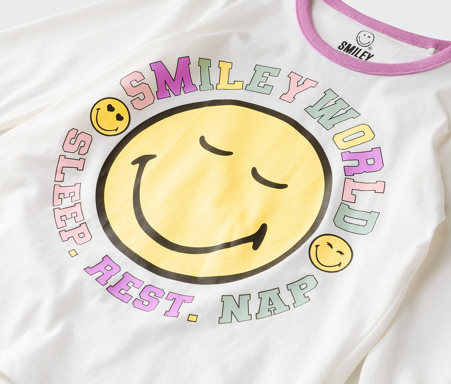 T-shirt blanc à manches longues avec un grand smiley jaune et l'inscription « Smiley World, Sleep, Rest, Nap ».