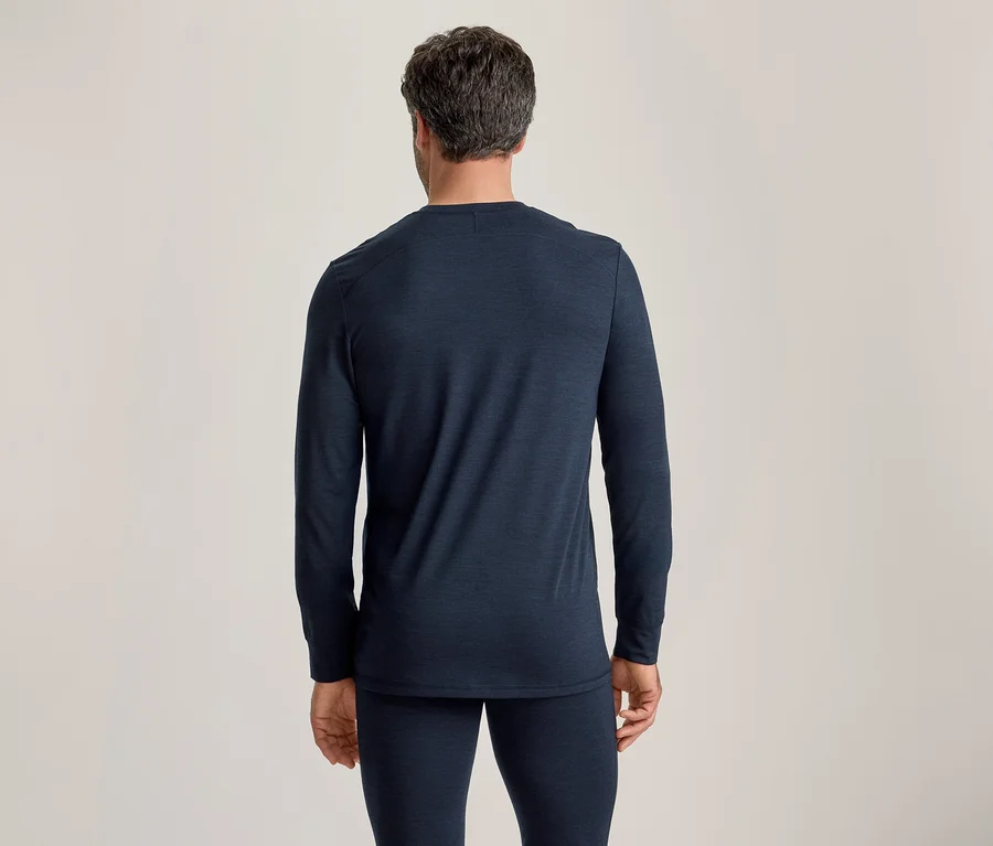 Homme vu de dos, portant un haut à manches longues bleu foncé et un pantalon long assorti sur un fond uni.