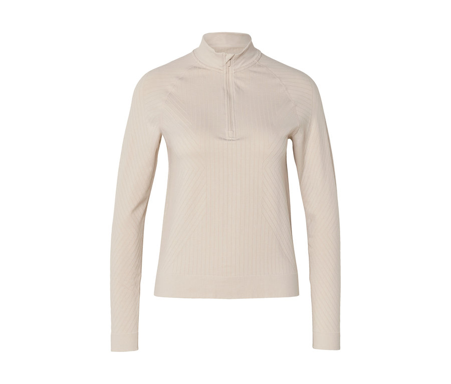 Haut à manches longues beige clair avec col montant zippé, présentant une texture côtelée verticale et de subtils motifs géométriques sur la poitrine et les côtés.