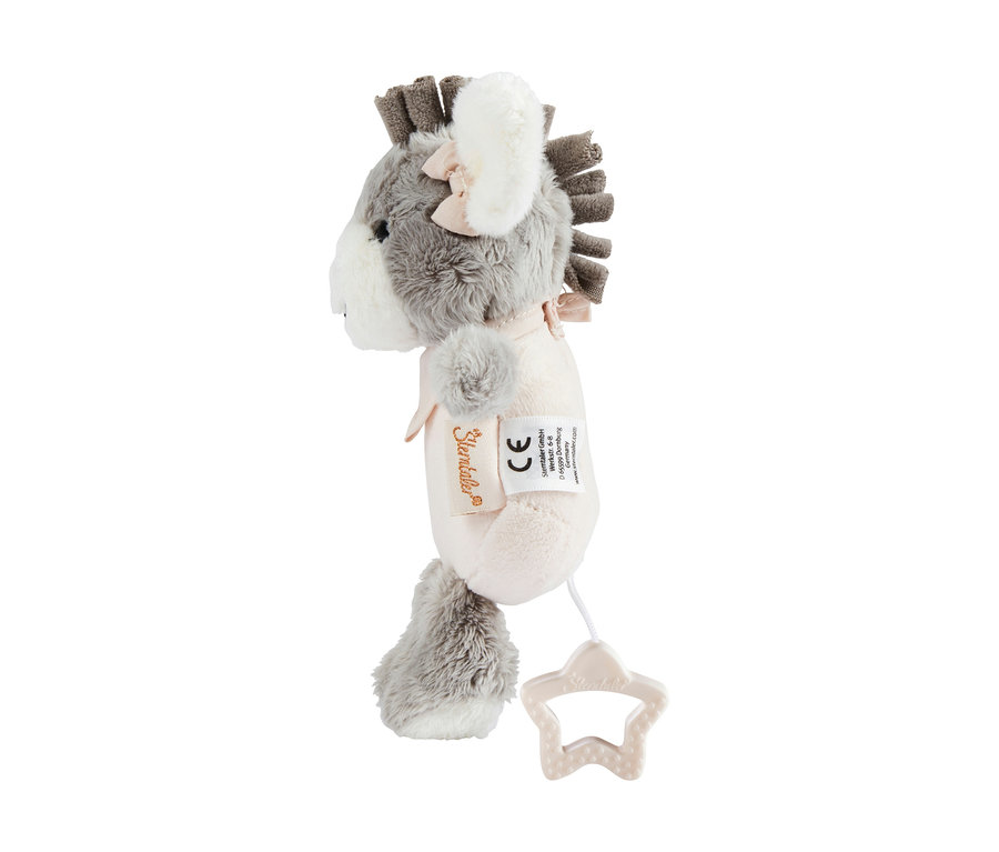 Une peluche musicale en forme d'âne gris et blanc, vue de côté. Elle a une crinière grise, des oreilles intérieures blanches avec un nœud rose et un ruban rose autour du cou. Une ficelle blanche avec une poignée de traction en forme d'étoile beige dépasse de sa partie inférieure. Deux étiquettes sont visibles sur le côté.