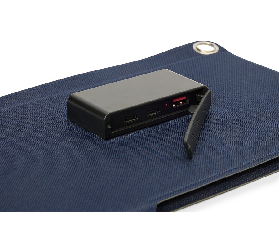 Une batterie noire posée sur une surface en tissu bleu, avec le port USB visible.