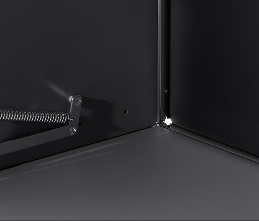 Vue détaillée de l'intérieur d'un meuble noir « CN3 » avec abattant, mettant en évidence le coin et le mécanisme d'ouverture.