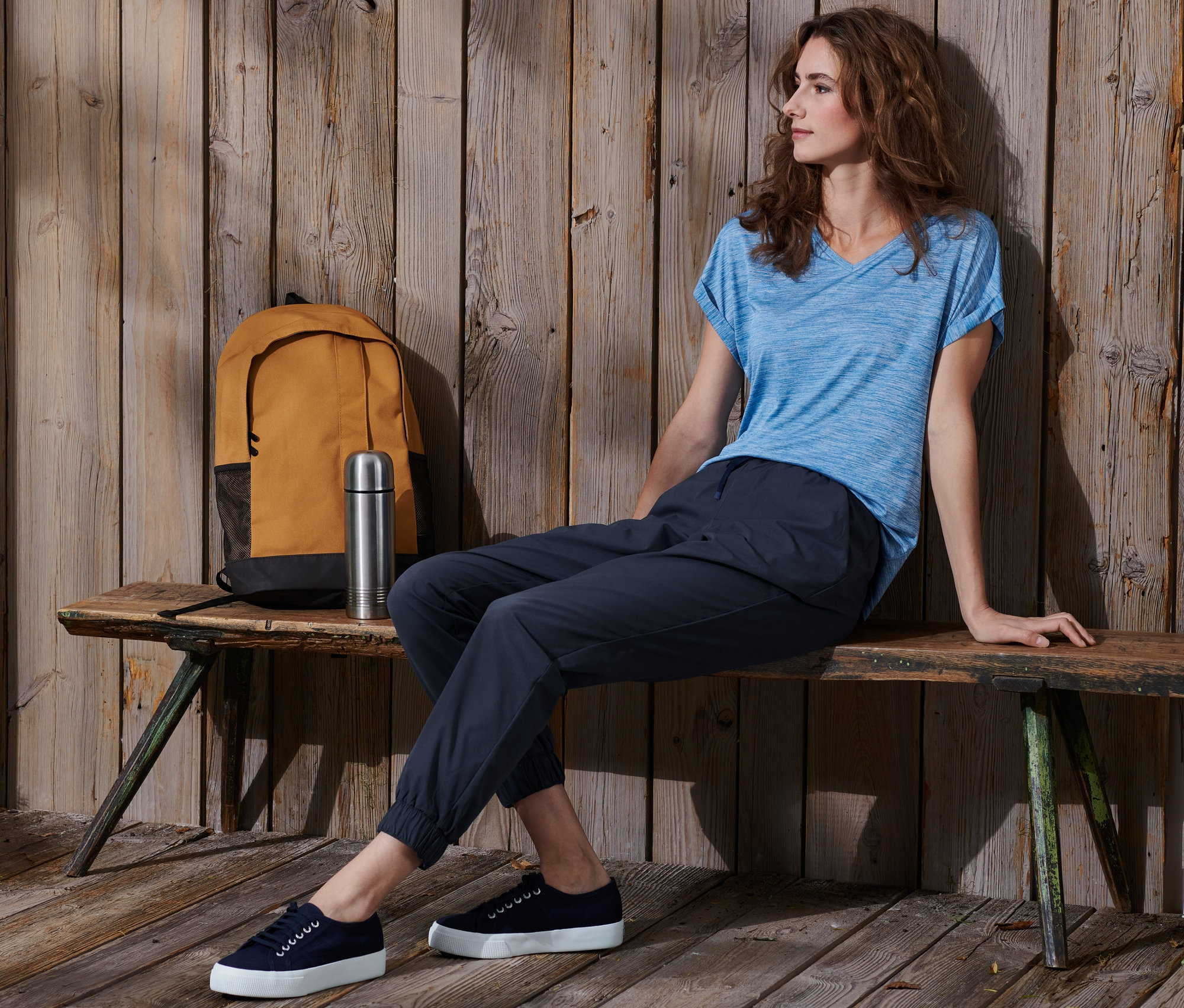 Femme assise sur un banc portant un jogpant softshell.