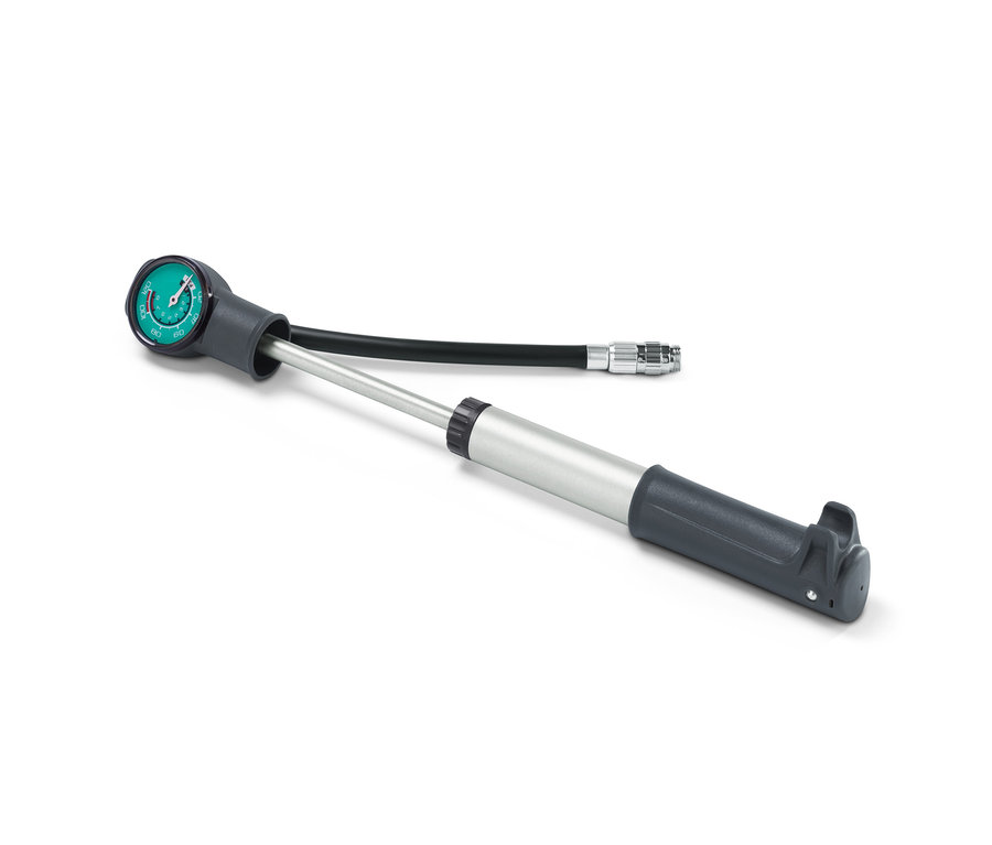 Une mini pompe double course grise avec manomètre et tuyau flexible sur fond blanc.
