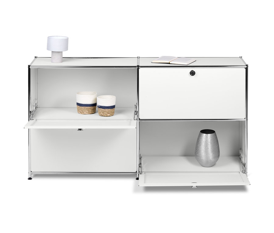 Buffet en métal blanc « CN3 » avec 4 compartiments à abattant. Deux paniers, une lampe et un vase sont posés sur les étagères.