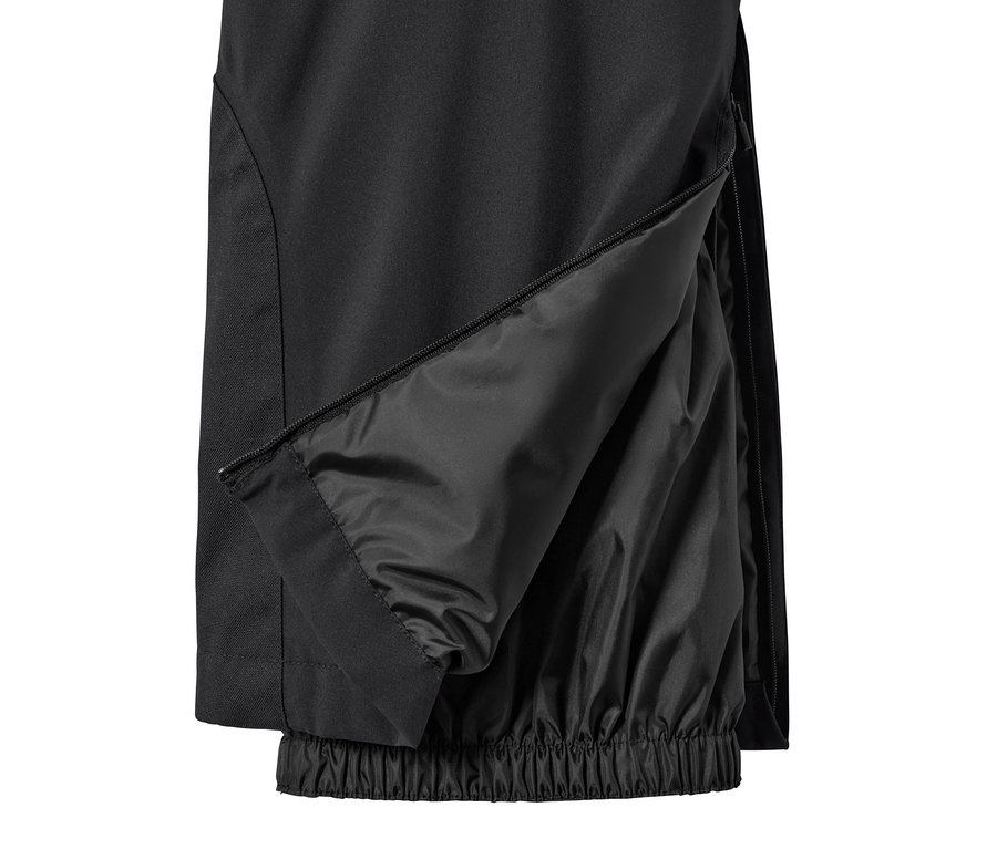 Gros plan sur un pantalon de ski noir avec une fermeture éclair sur la jambe.