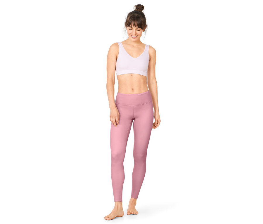 Femme portant un legging de sport réversible rose.