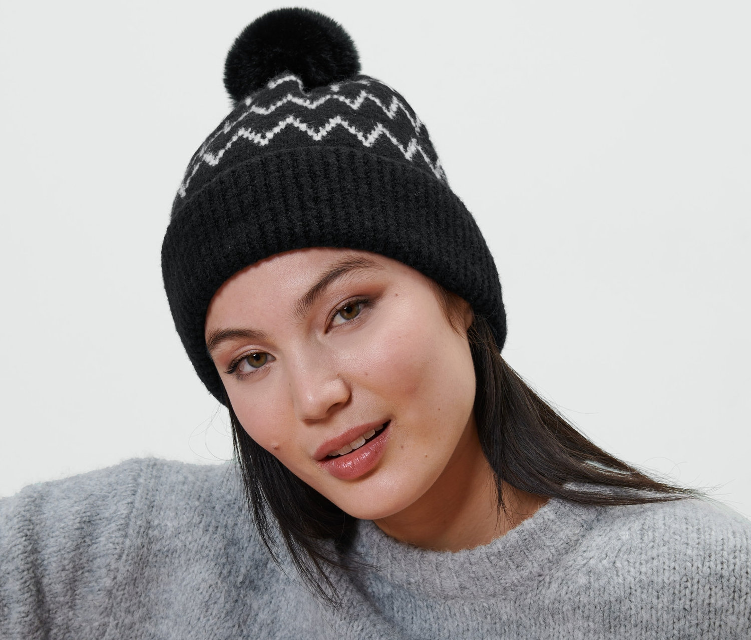 Une femme portant un bonnet en maille avec pompon.