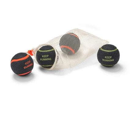Quatre balles pour chien sont partiellement placées dans un sac en filet. Les balles sont gris foncé avec des rayures colorées et l'inscription « Keep Running ».