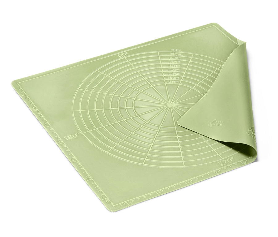 Un tapis de cuisson réutilisable vert clair avec des cercles et des angles repose sur un fond blanc.