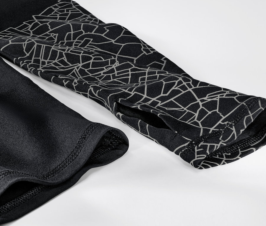 Gros plan sur un t-shirt technique à manches longues noir et argenté.