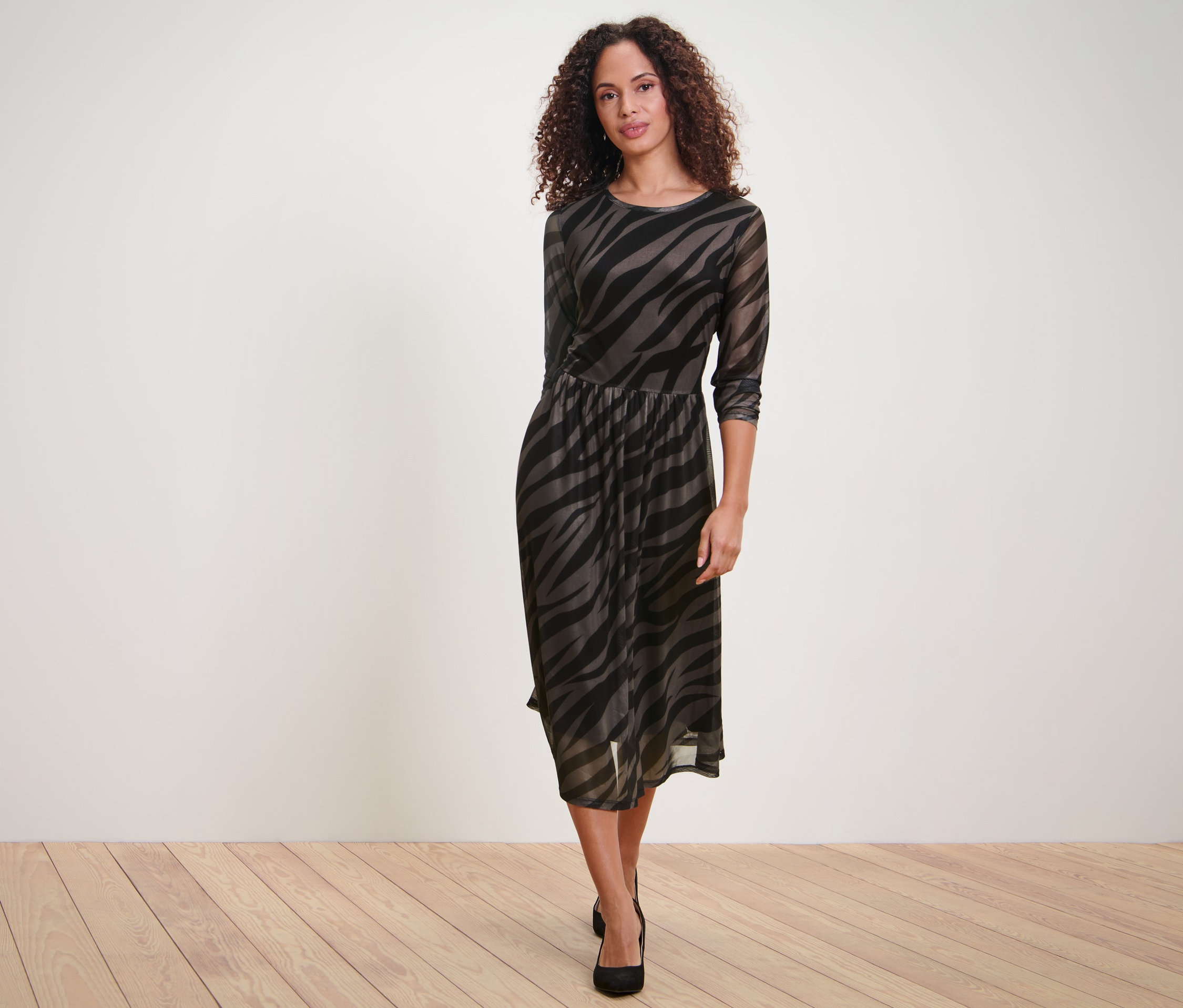 Femme posant dans une robe en mesh imprimée.