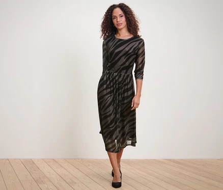 Femme posant dans une robe en mesh imprimée.
