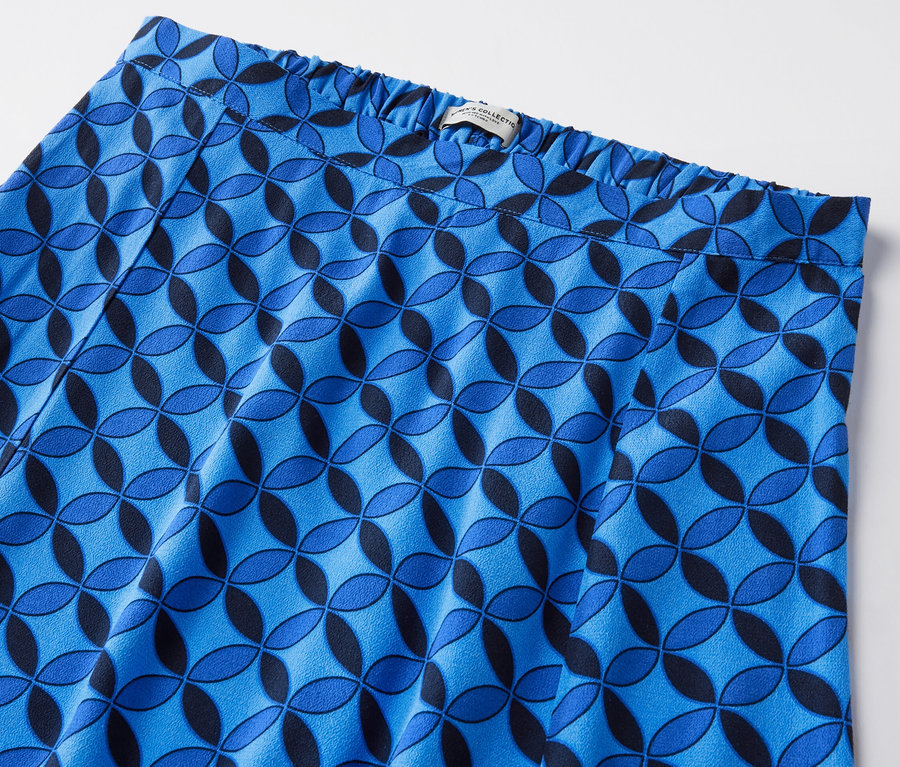 Gros plan d'une jupe midi imprimée bleu foncé avec un motif géométrique.