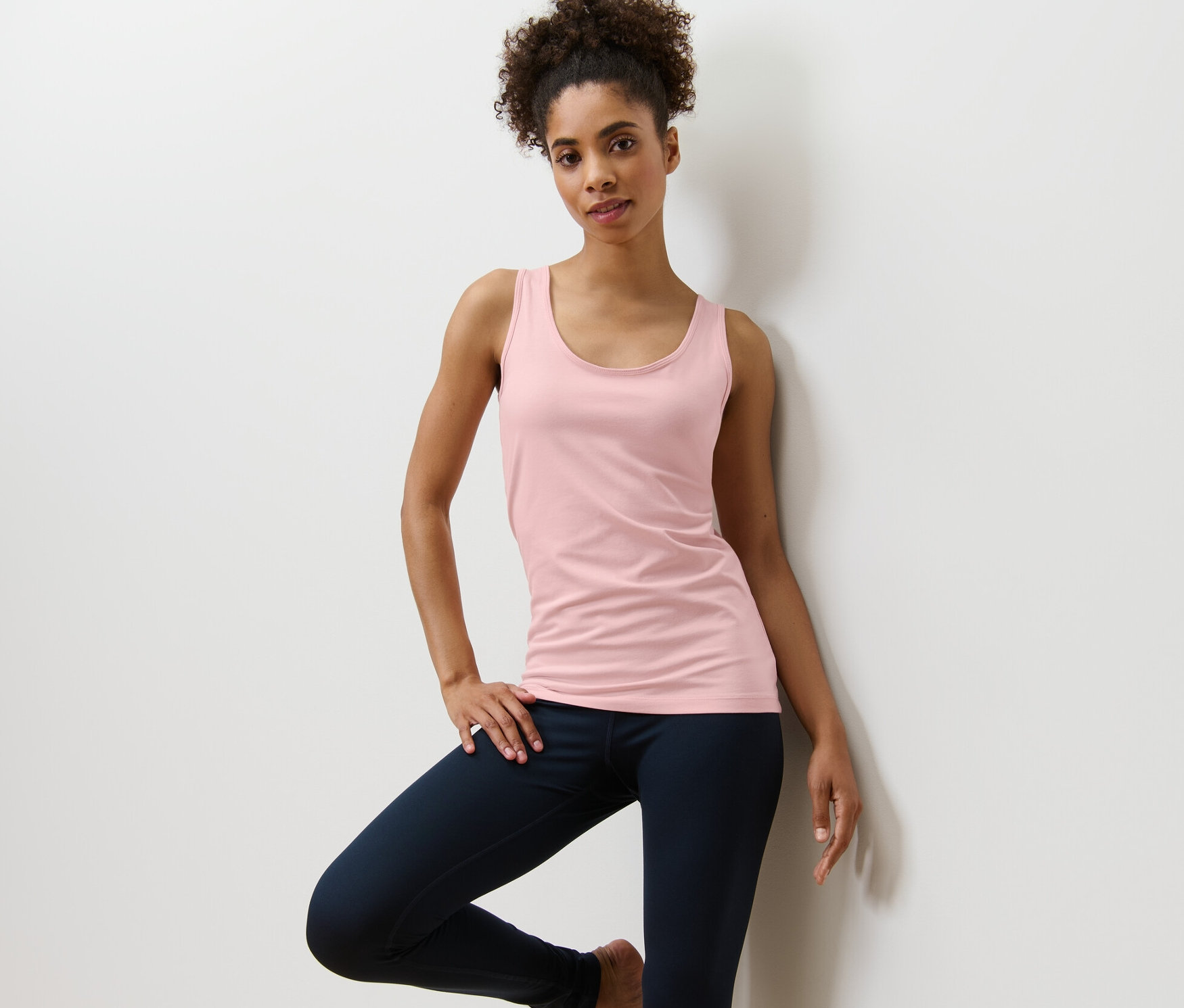 Femme posant dans un top rose d'un ensemble de 2.