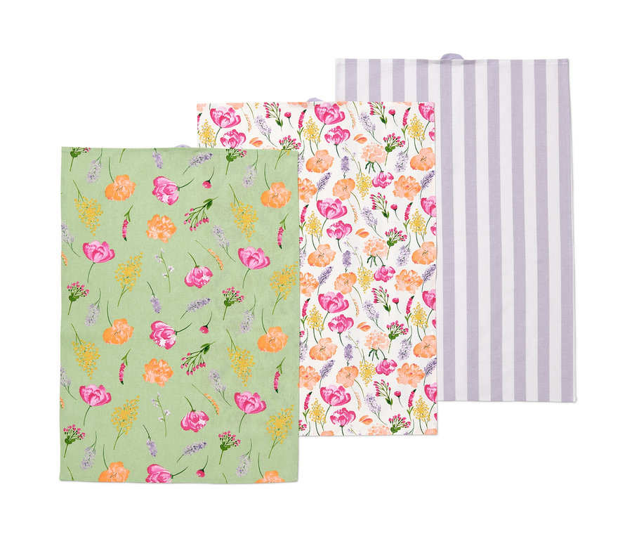 Trois torchons : un vert à motif floral, un à fleurs et un blanc à rayures violettes.