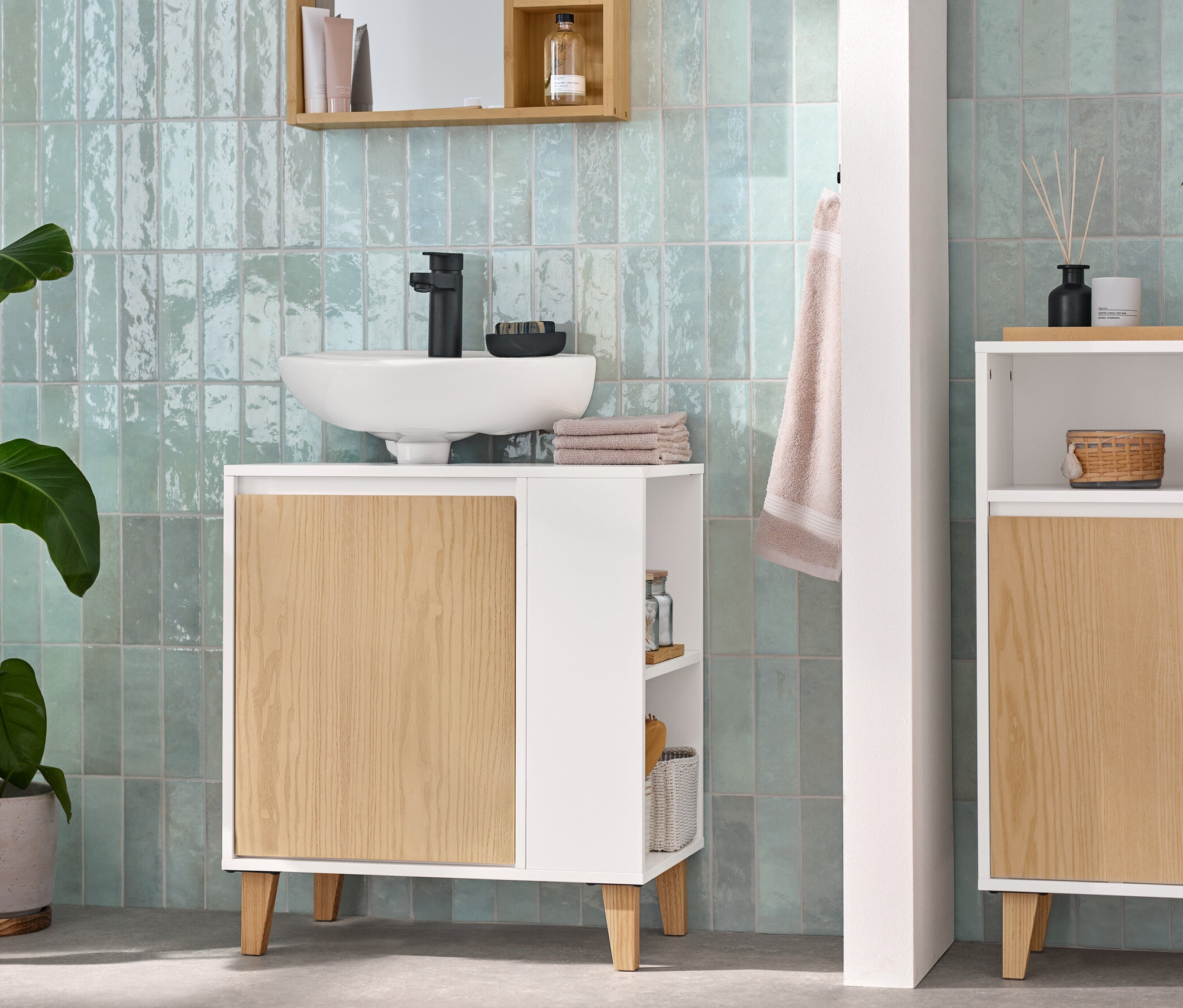 Salle de bain avec un miroir avec étagères, meuble sous-vasque avec porte et compartiment latéral, et un meuble avec 2 portes et un compartiment ouvert.