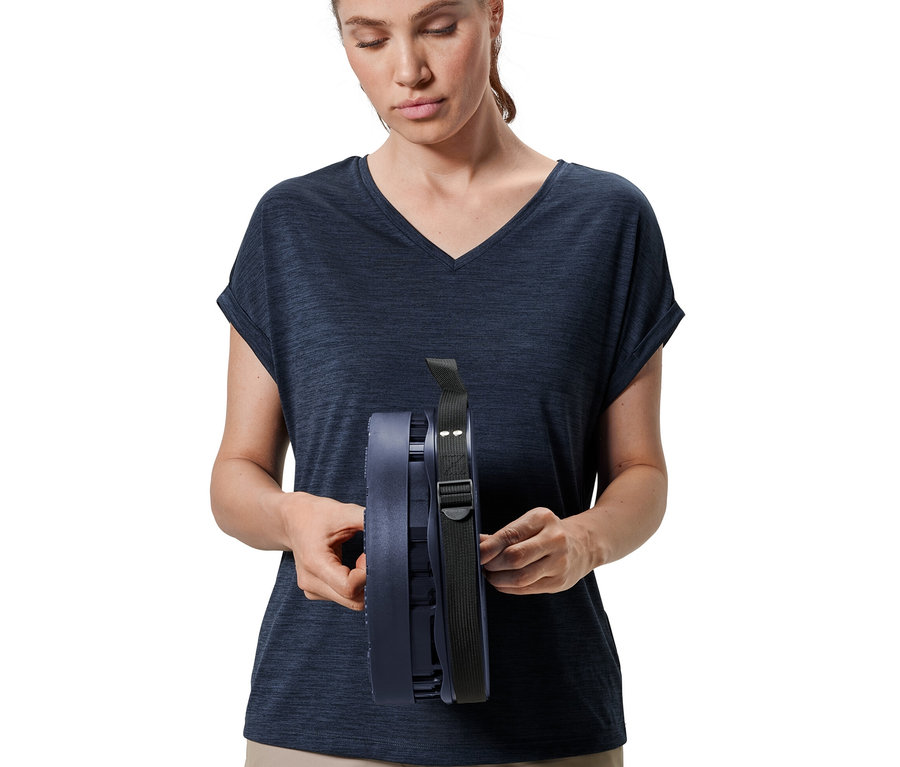 Femme tenant un tabouret de camping télescopique.