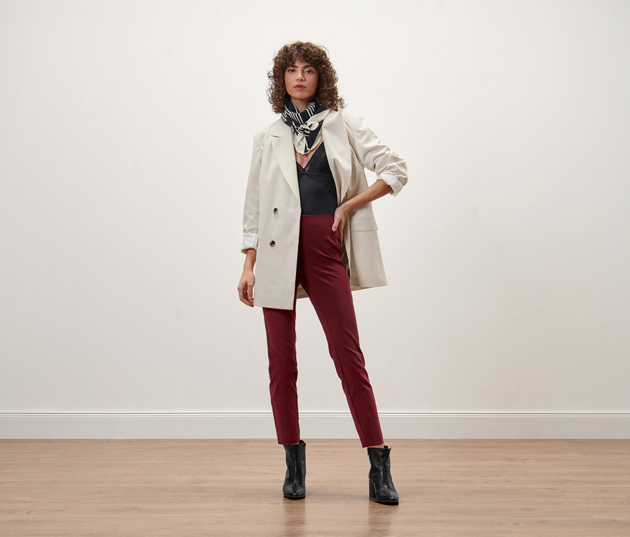 Femme posant en blazer, top et pantalon confort.