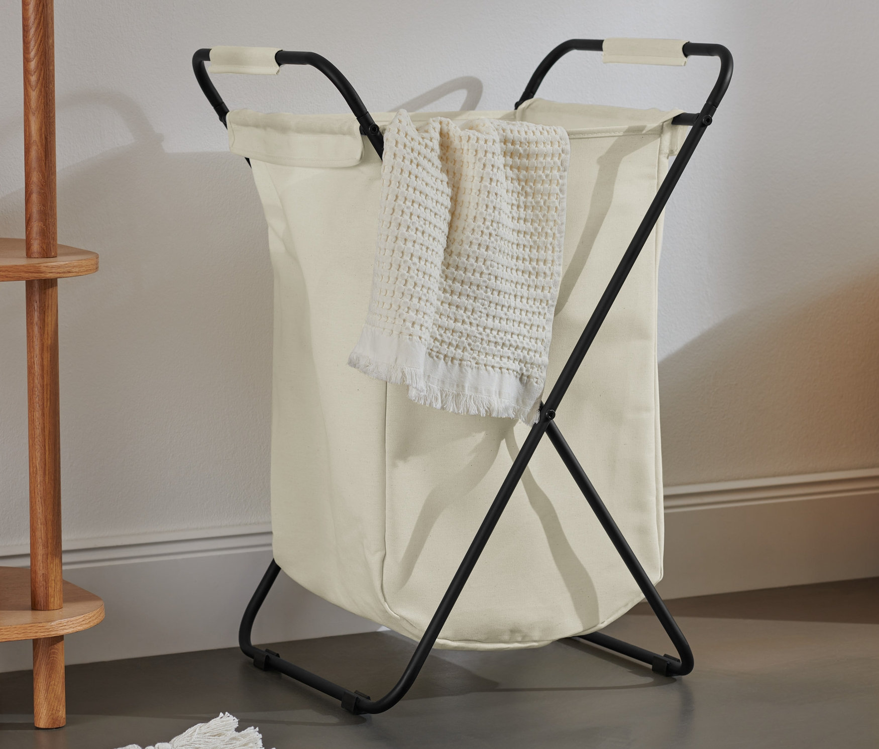 Un panier à linge pliable avec une serviette suspendue sur le côté.