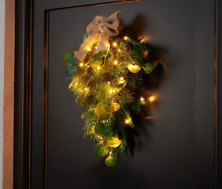 Une décoration de porte LED est accrochée à une porte noire.