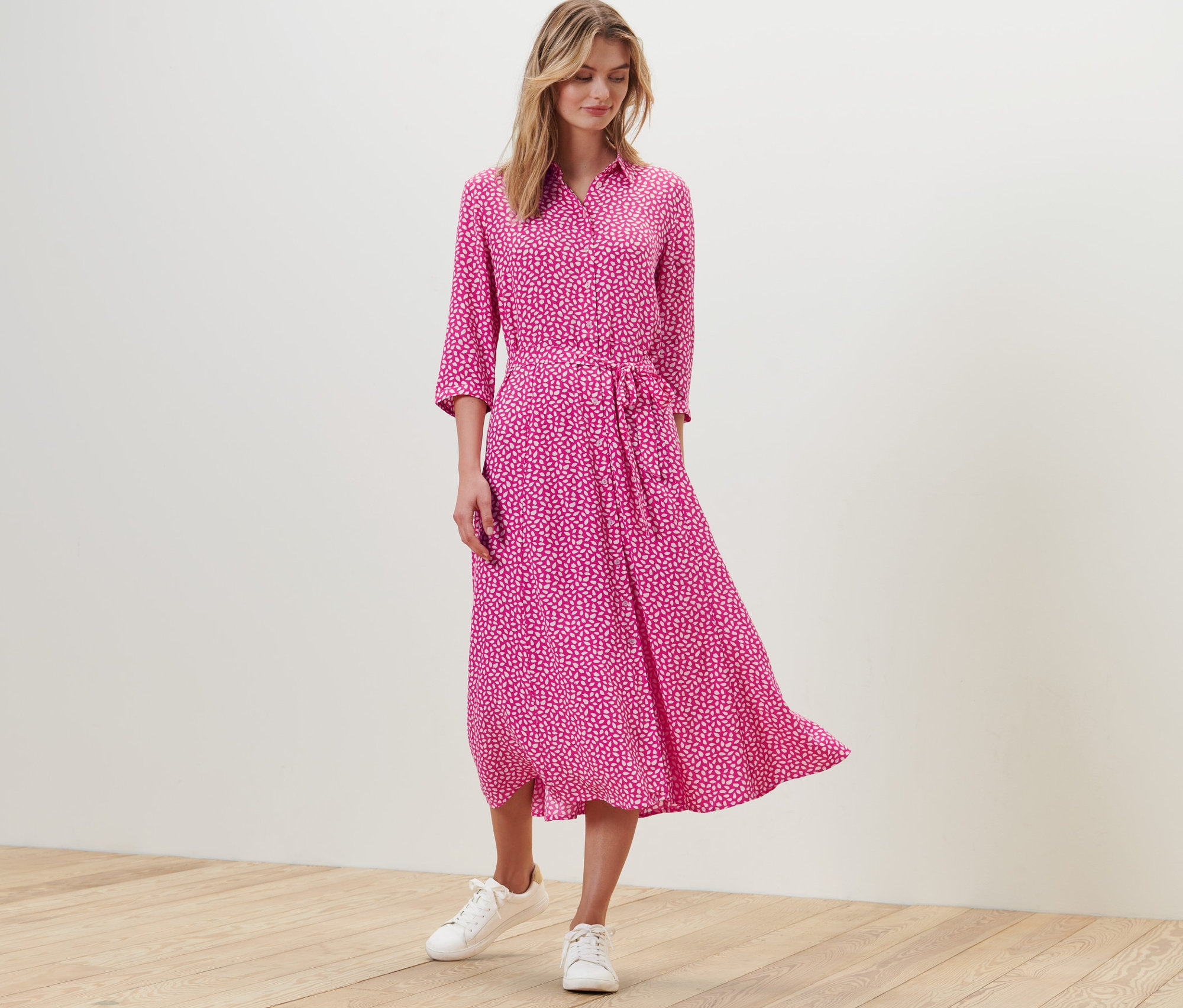 Une femme debout portant une robe chemise imprimée.