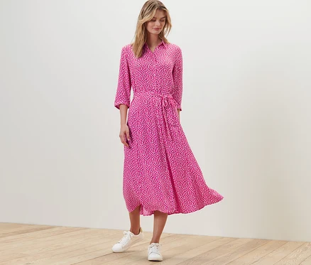 Une femme debout portant une robe chemise imprimée.