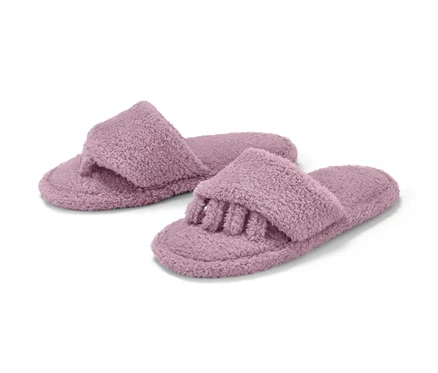 Deux pantoufles de relaxation violettes en tissu éponge.