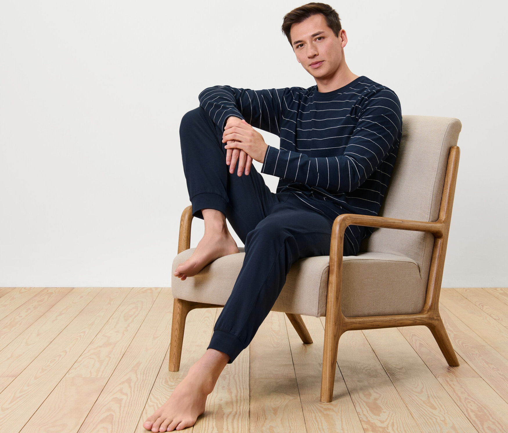 Un homme est assis dans un fauteuil et porte un pyjama.