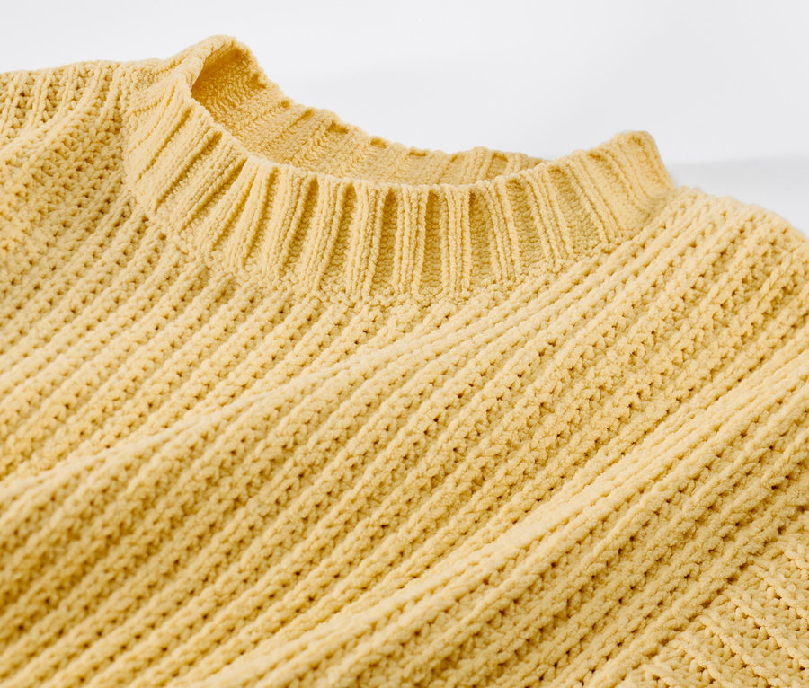 Détail d'un pull en chenille pour enfant, jaune colza.