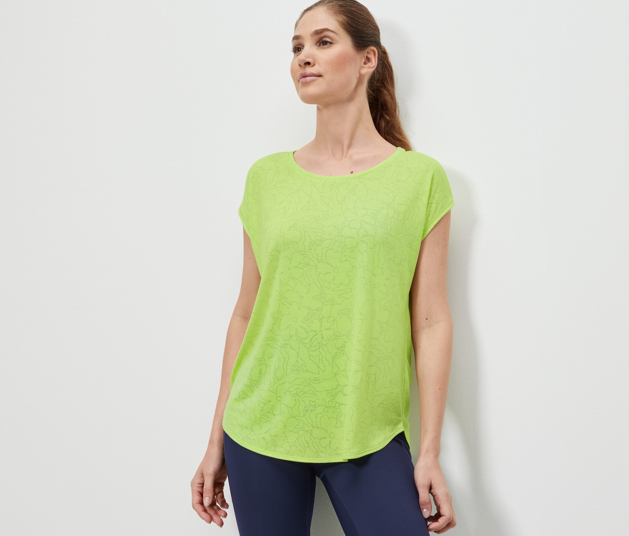 Femme portant un t-shirt de sport vert citron.