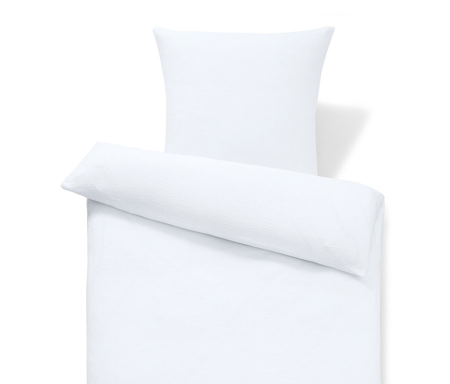 Gros plan d'un ensemble de literie blanc comprenant une housse de coussin et une housse de couette.