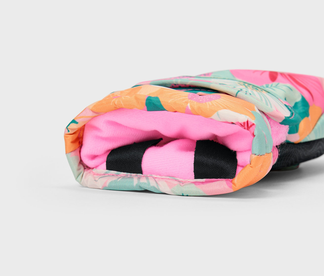 Détail d'une housse colorée à motif tropical avec un intérieur rose.