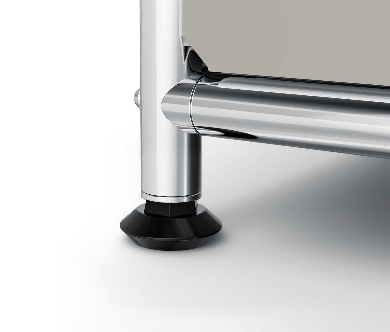 Gros plan sur le pied chromé et la base noire d'un meuble.