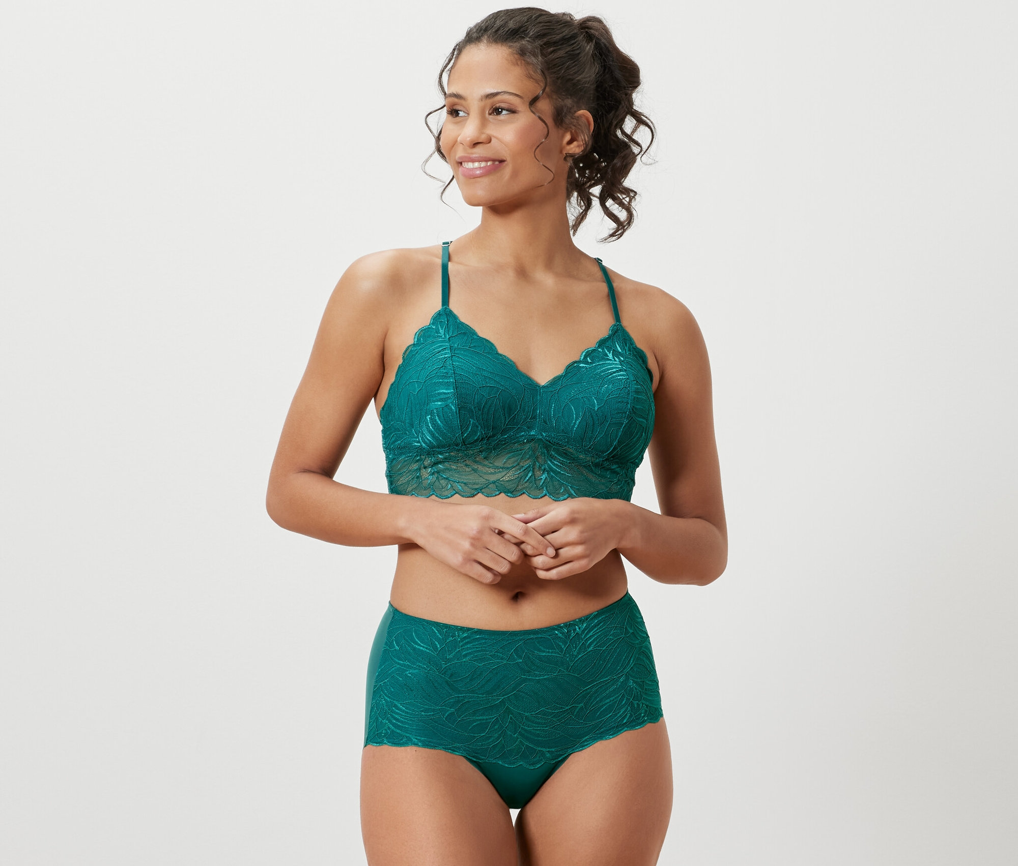 Une femme porte un ensemble de lingerie en dentelle pétrole et une culotte taille haute « light-shaping », pétrole.