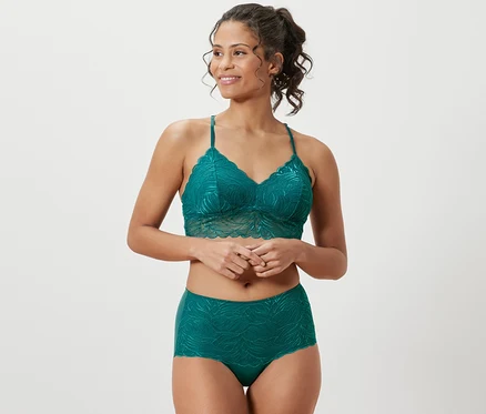 Une femme porte un ensemble de lingerie en dentelle pétrole et une culotte taille haute « light-shaping », pétrole.