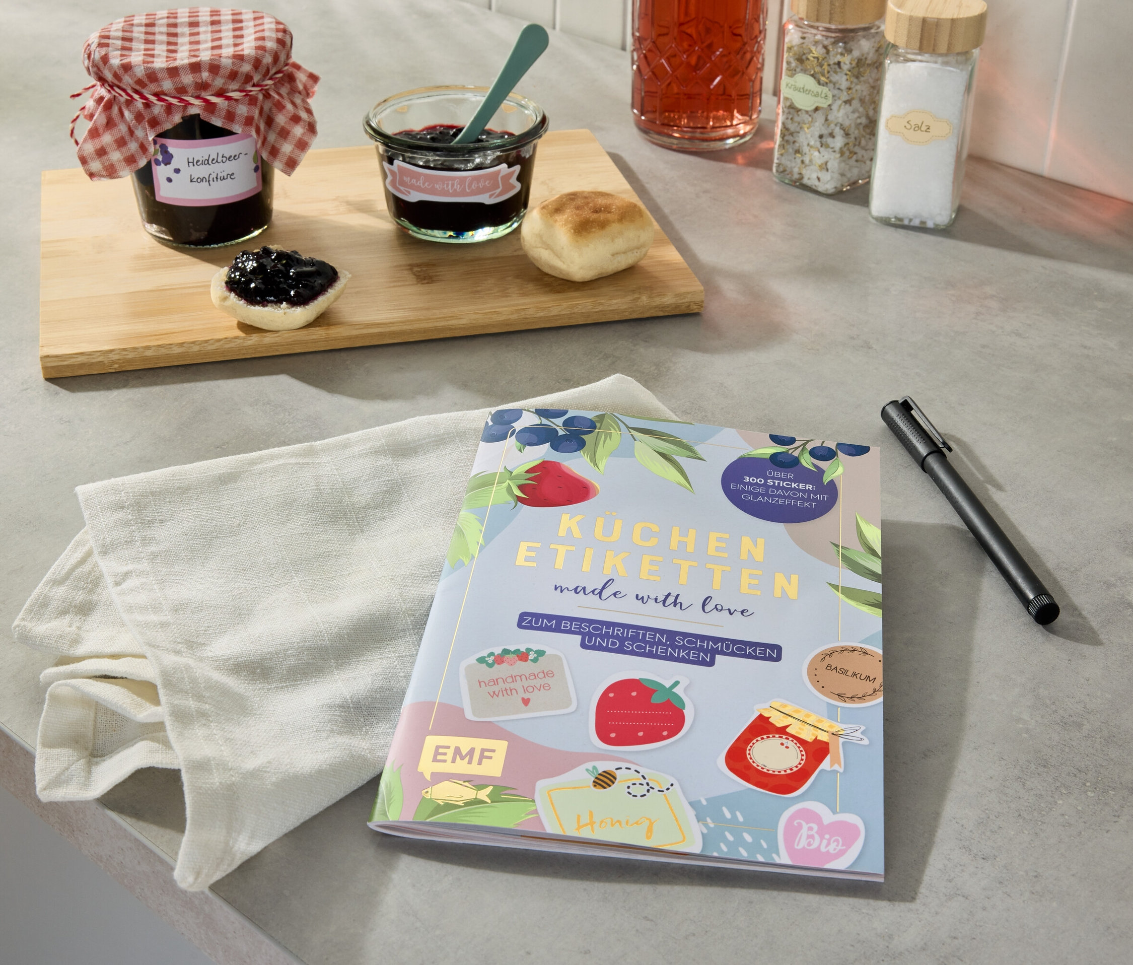 Pots de confiture et un livre d'étiquettes de cuisine sur un comptoir de cuisine.