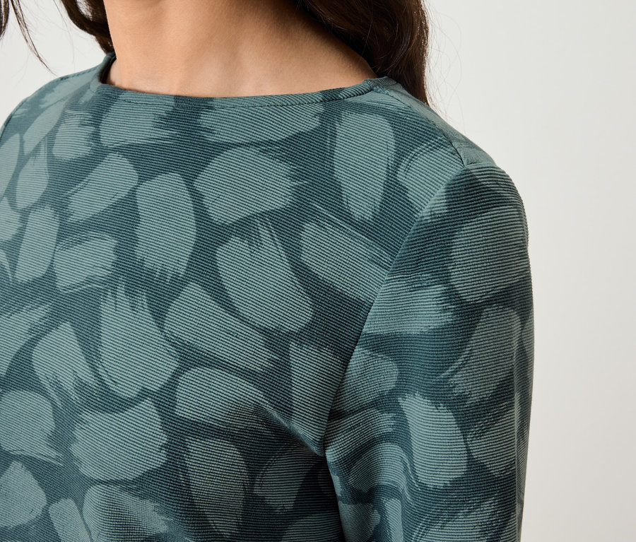 Gros plan sur une robe à manches longues pour femme avec un imprimé abstrait.