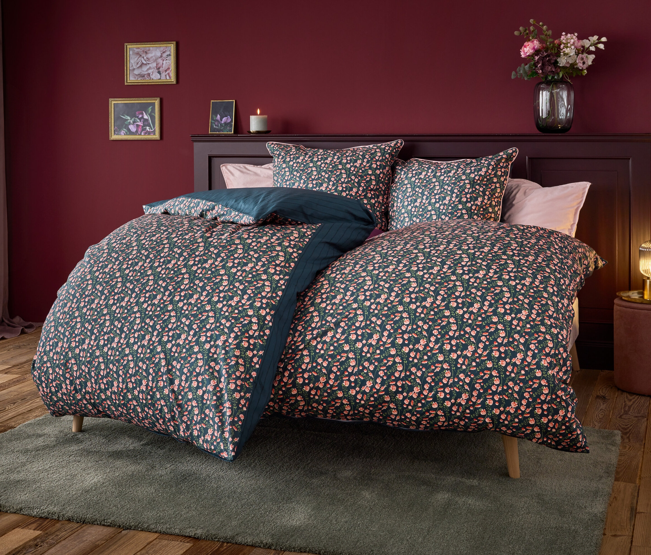 Lit avec literie bleu marine à motif floral.