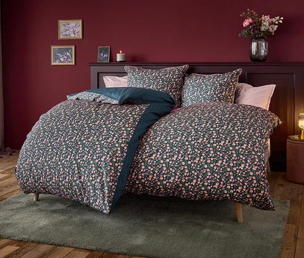 Lit avec literie bleu marine à motif floral.