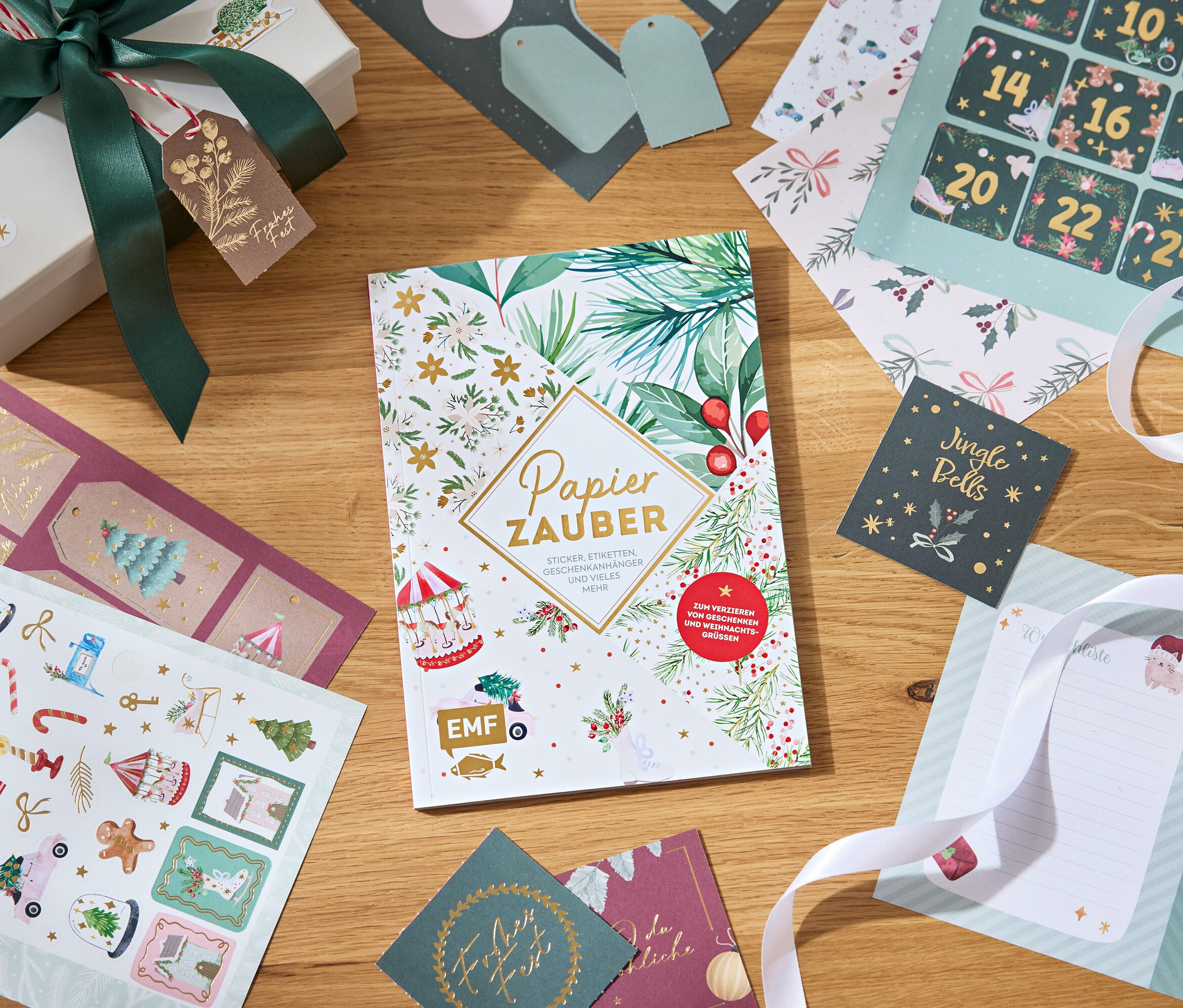 Papiers décoratifs, autocollants et boîte cadeau avec un ruban sur une table en bois.