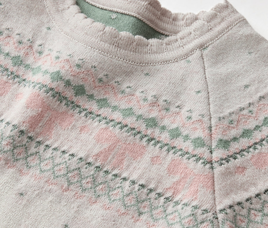 Gros plan sur un pull gris à motifs rose et vert avec un col à froufrous.