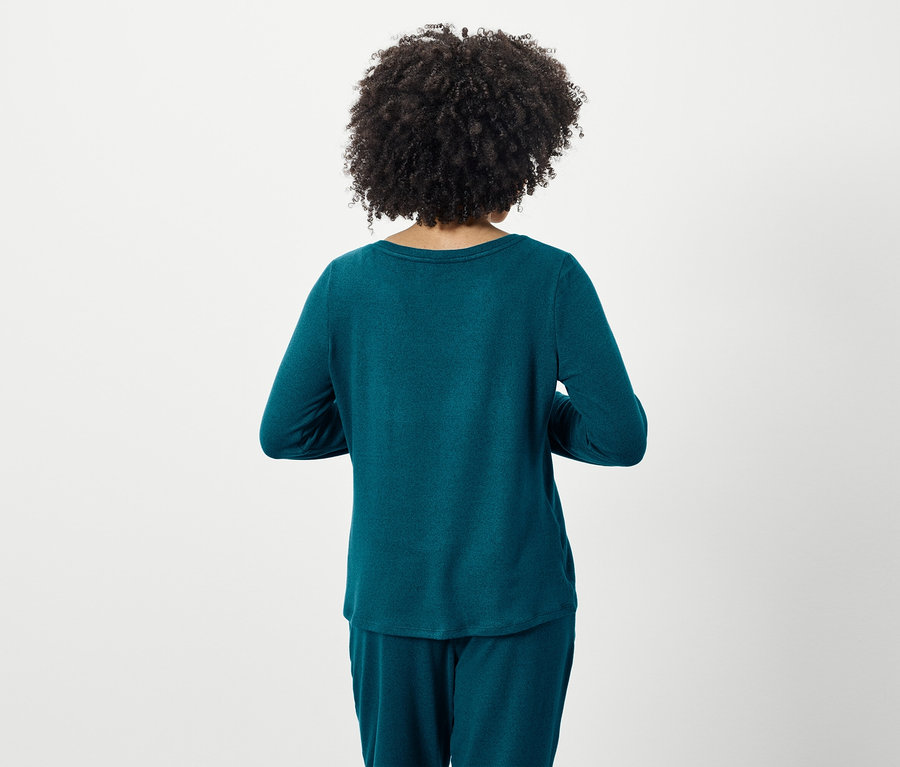 Vue arrière d'une femme avec une coiffure afro, portant un pyjama turquoise à manches longues et un pantalon.
